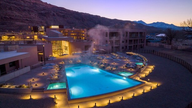 A hotel with a pool, lounge chairs, and a mountainous backdrop. - Moab | Desert Basecamp Retreat | Pool + Hot Tub | 2BR (Moab)