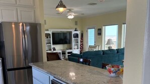 A kitchen with a built-in microwave, a stainless steel refrigerator, and a granite countertop. - Beachfront Escape – Beach Views from Wraparound Porch•Private Walkover W Seating (Freeport)