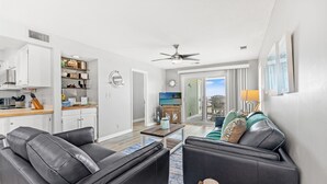 A modern living room with a sofa, coffee table, and a television. - Coastal Shores - Direct Oceanfront w/ Pool in North Myrtle Beach (North Myrtle Beach)
