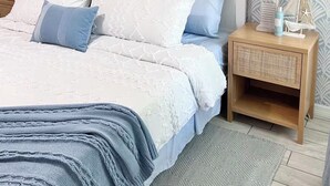 Une chambre à coucher avec un lit, des tables de chevet et des œuvres d’art murales.