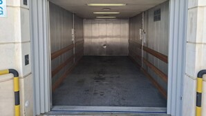 An elevator interior with metallic walls, a metal floor, and a door with a sign indicating a weight limit of 1700 kg. - PRAIA DA ROCHA - DOM QUIXOTE (Portimão)