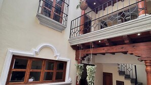 A multi-level atrium with a central fountain, balconies, and a staircase. - Terrace with volcano view/ Colonial Villa + Parking in Antigua Guatemala (Antigua Guatemala)