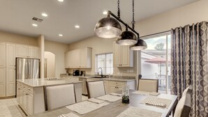 A modern kitchen with a central island, stainless steel appliances, and pendant lighting. - Quiet 4BR Home w/ Pool Near Summerlin and Strip Central to Everything (Las Vegas)