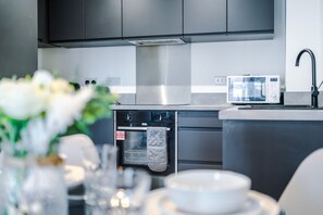 A modern kitchen with stainless steel appliances, a built-in oven, and a microwave. - Stylish 2BDR City Apartment In Liverpool (Liverpool)