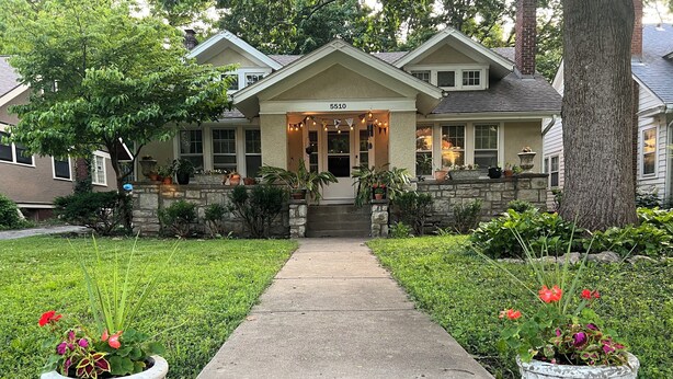 A two-story house with a stone facade, a front porch, and a number '5510' displayed above the entrance. - Sunny, safe, walkable house with King bed and AC (Kansas City)