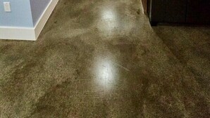 Un corridoio stretto con un frigorifero in acciaio inossidabile sulla destra, pareti azzurrine e una porta in fondo.