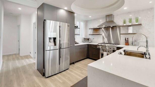 Una cucina moderna con elettrodomestici in acciaio inossidabile, un'isola centrale e un forno a incasso.