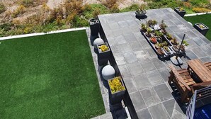 A rooftop patio with a view of the ocean, a grassy area, and a pool. - Mystic Falls Apartment on the Bay (St. Helena Bay)