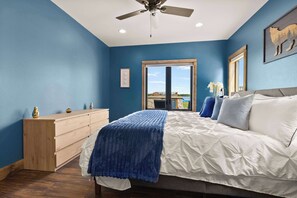 Un dormitorio con cama, cómoda y vistas al exterior a través de una ventana.