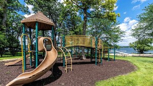 A playground with a slide, climbing structures, and a gazebo. - Lakeside Living at Abbey Springs - Pools & Beach! (Fontana)