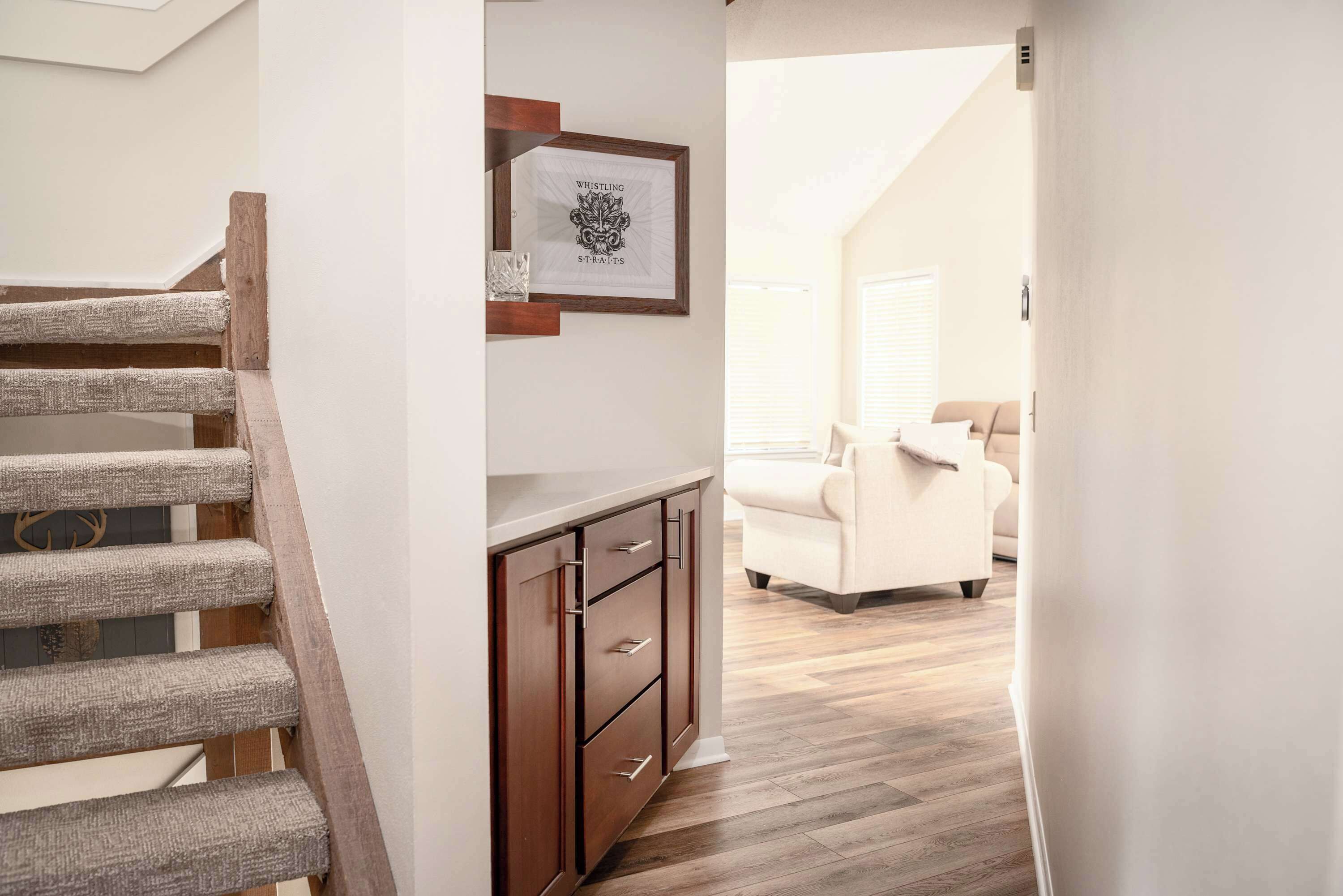 A staircase with a wooden handrail and a wall-mounted picture frame.