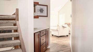 A staircase with a wooden handrail and a wall-mounted picture frame.