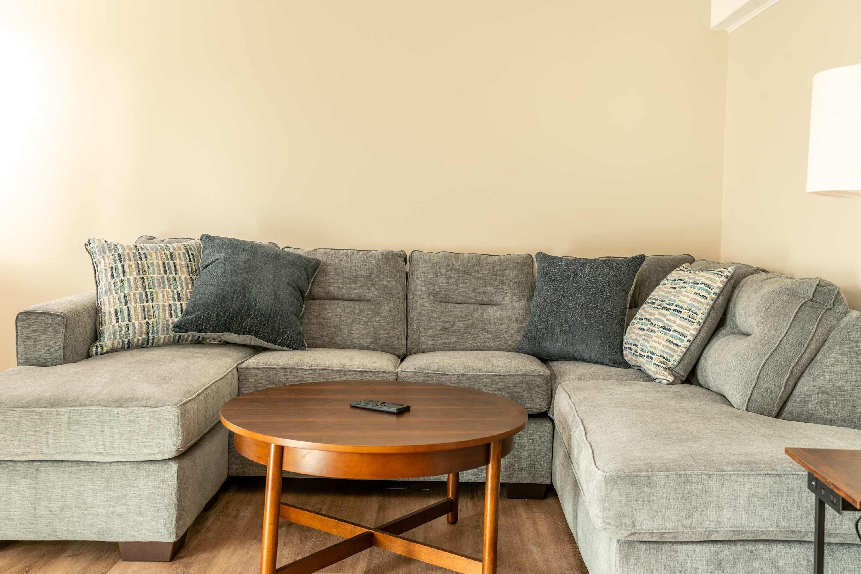 Ein modulares Sofa mit einem runden Couchtisch davor.