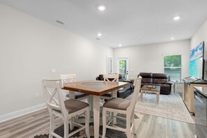 A modern living room with a dining table, a sofa, and a TV. - Marigold House: Foley (Foley)