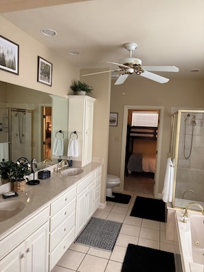A bathroom with a vanity, mirror, sink, and shower. - The Bass Shack (Alba)