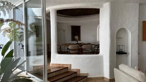 A modern interior with a dining area, a staircase, and a seating area. - Casa di Campara Villa Faro (Faro)