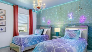 A bedroom with two beds, a chandelier, and a wall decorated with a net and sea-themed neon lights. - Upstay Mansion w Cinema, Games, Pool- Sleeps 24! (Kissimmee)