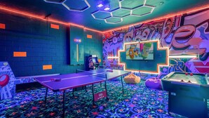 A room with a ping pong table, a foosball table, and a wall with graffiti art. - Upstay Mansion w Cinema, Games, Pool- Sleeps 24! (Kissimmee)