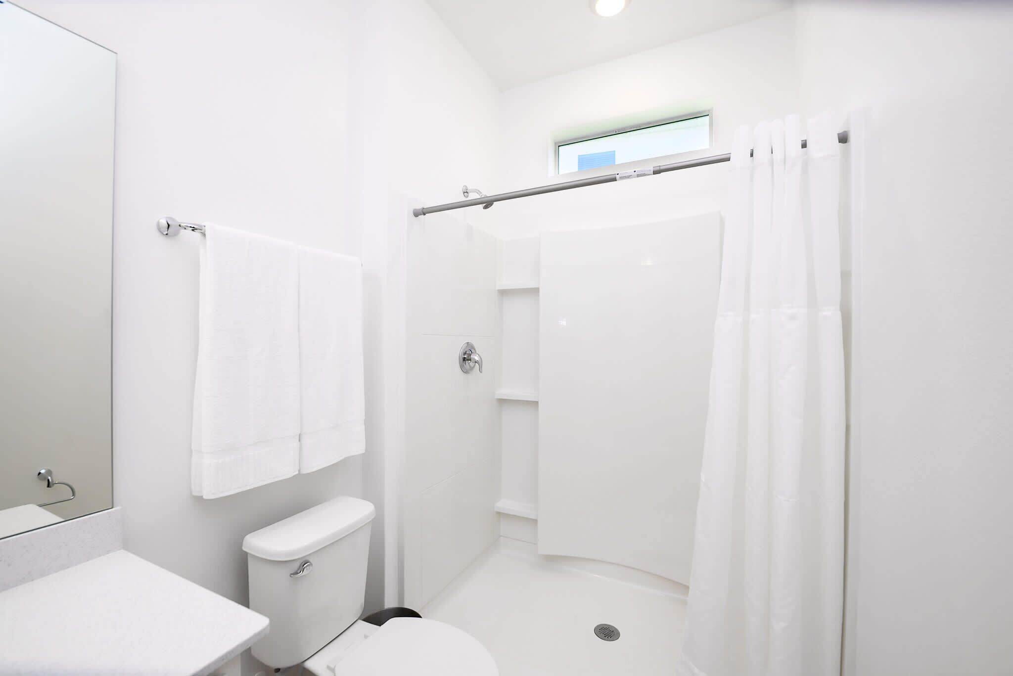 A modern bathroom with a toilet, sink, and shower area.