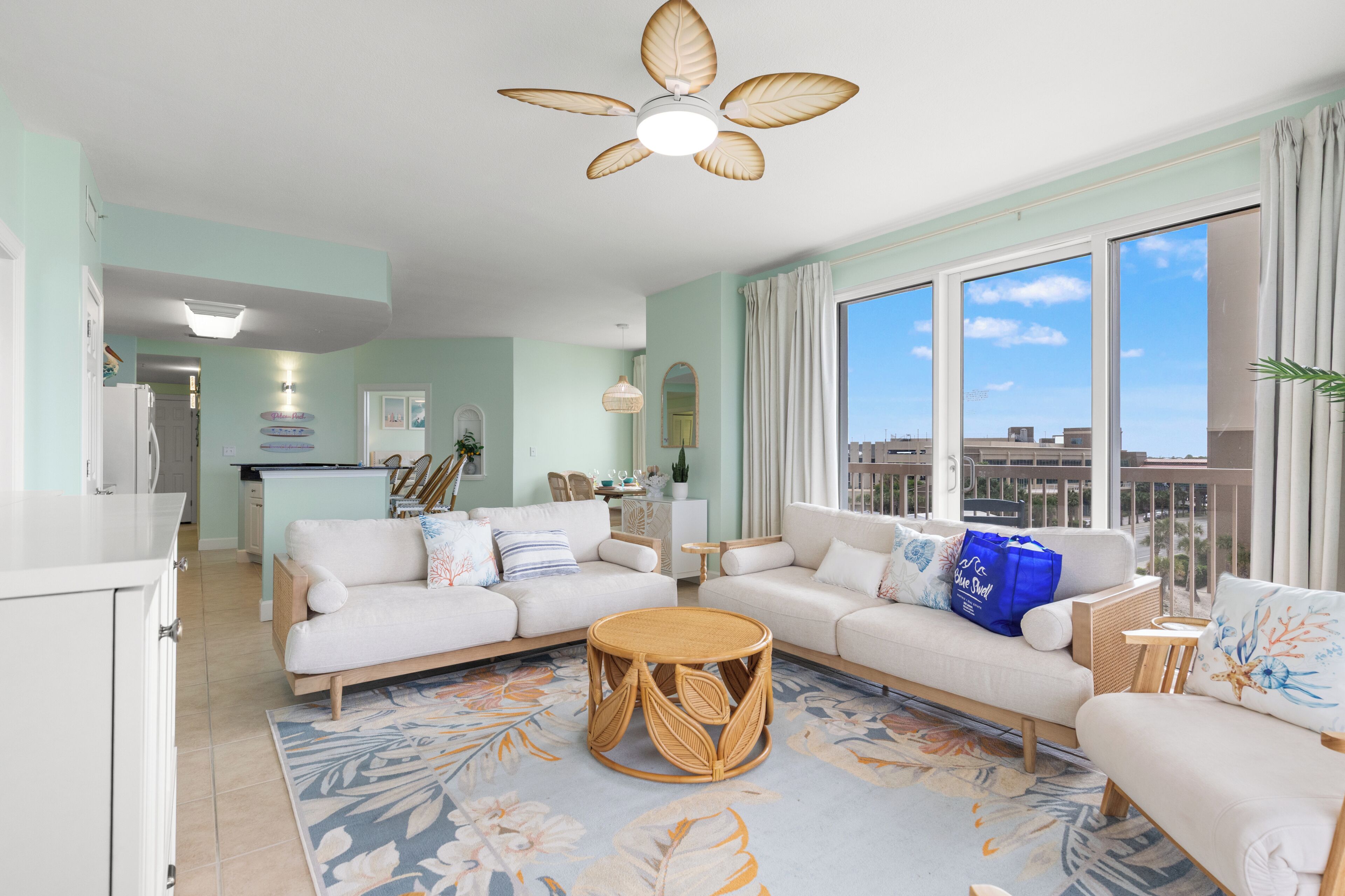 A living room with a sofa, a round coffee table, and a ceiling fan.