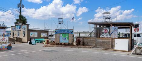 Una propiedad frente al agua con un cartel que indica 'Fisherman's Walk' y 'Angler's Axe House'.