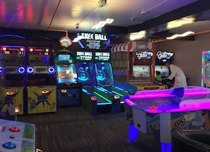 An arcade with various gaming machines, including 'Skee Ball' and 'Big Save' games, and a person playing a game. - 4-bedroom Luxury Ski Loft at Westgate Resort Park City (Park City)