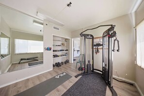 A home gym with a pull-up bar, weight bench, and dumbbells. - Kauai Mini Kitchenette  Pono Kai Resort  K205 (Kapaʻa)