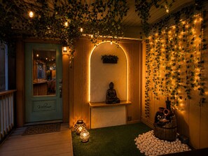 A cozy interior with a Buddha statue, string lights, and a wooden barrel. - Romantic Riverfront Views Private Pool HotTub Fireplaces Pets BBQ Luxe Amenities (Jeffersonville)