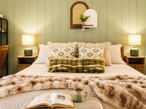 A bed with a fluffy blanket, pillows, a book, and a mug on a wooden nightstand. - Romantic Waterfront Views HotTub Fireplaces BBQ Private Pool Pets Luxe Amenities (Jeffersonville)
