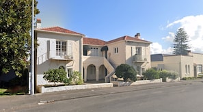 A two-story building with a balcony, a staircase, and a driveway. - Character 1 BDR 1920s apartment Mount Eden Village (Auckland)