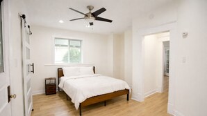 A bedroom with a bed, a ceiling fan, a window, and a door. -     Cozy Atlanta Stay Sleeps 4 Near ATL. Free Wifi + Self check in (College Park)