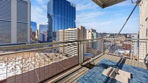 Un immeuble de grande hauteur offrant une vue sur le paysage urbain, avec notamment des gratte-ciel modernes et un parking.