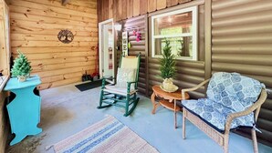 A wooden cabin interior with a rocking chair, a small table, a wicker chair, and a decorative tree. - 20 Mins To Hershey Park w/ Farm Animals & Firepit! (Grantville)