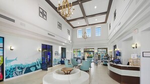 Eine geräumige Lobby mit einer zentralen Sitzecke, einem Empfangstresen und einer großen Chandelier.