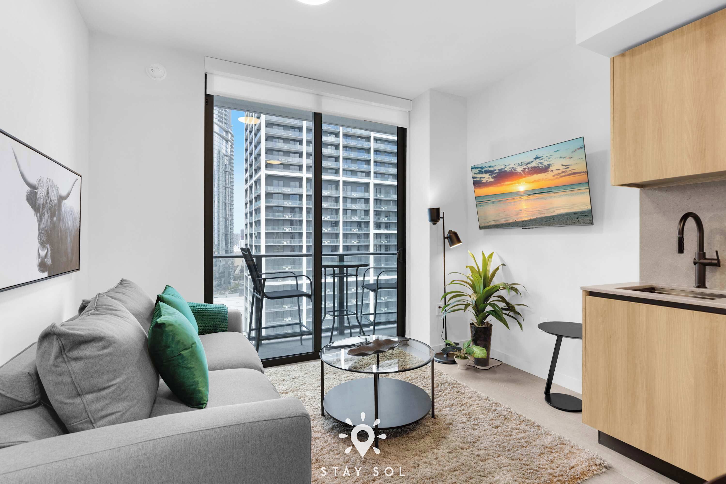 A modern apartment with a balcony, a dining area, and a kitchen.