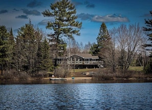 A house by a lake with a dock, surrounded by trees. - Winter Escape | Sauna, Fireplace, Games (Parry Sound)