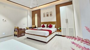 A modern bedroom with a bed, bedside tables, a wardrobe, and a ceiling fan. - TrueLife SRB Suites (Tirupati)