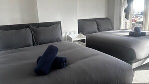 A hotel room with two beds, a white nightstand, and a window with a view of parked cars. - Tranquil Hideaway w/Hot Tub and Pool Table (Cardiff)