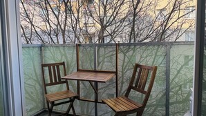Een hoekje met een houten tafel en twee stoelen, omheind door een gaashek.