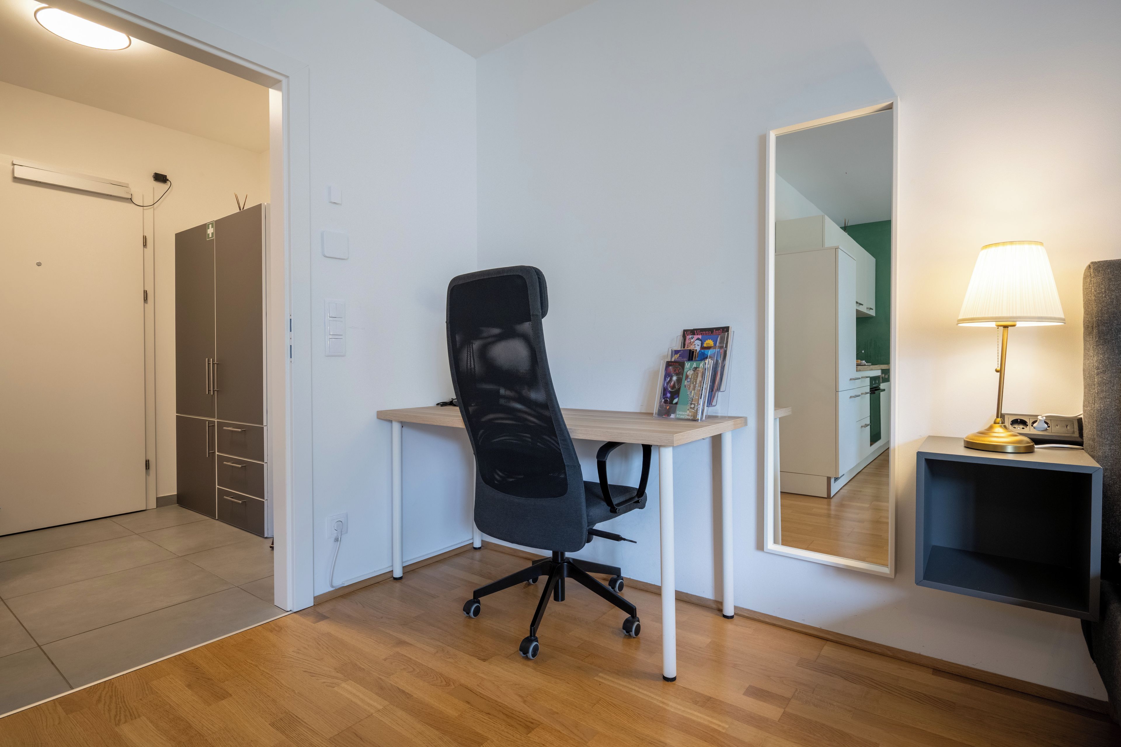 Ein moderner Arbeitsplatz mit Schreibtisch, Bürostuhl und einer Lampe.