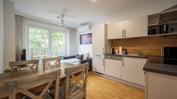 A modern kitchen with white cabinets, a wooden countertop, and a built-in oven.