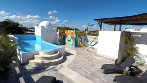 A rooftop pool area with a modern design, including a swimming pool, lounge chairs, and a colorful mural. - Air, King Bed, Kitchen, 50 Mbps Wi-Fi, V1 (Playa del Carmen - Valentina Suites)