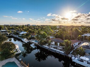 A marina with boats docked, a swimming pool, and residential buildings with palm trees. - Paradise in Pompano: Heated Pool, Dock, Water View (Pompano Beach)