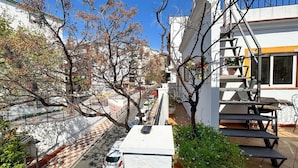 A narrow urban street with buildings, a parked car, and a staircase leading to a building entrance. - 2 bedroom amazing apartment in Marbella (Marbella)