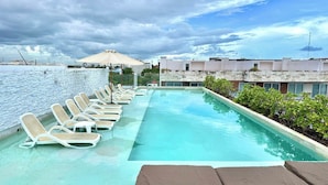 A rooftop pool with lounge chairs and a view of buildings. - Central 2 BR PH Gym, Private Rooftop, Garage, 406 (Playa del Carmen - Centro)