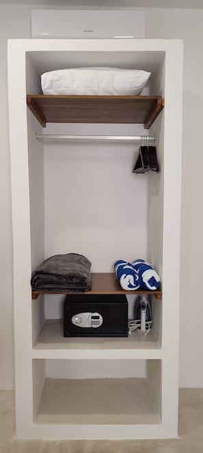 Ein weißer Kleiderschrank mit mehreren Einlegeböden, einer Kleiderstange und einer kleinen Aufbewahrungsbox.