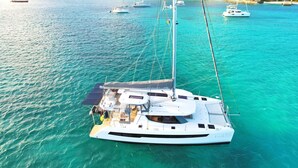 A white yacht with a covered deck and multiple masts, anchored in clear turquoise waters. - Apartment TalyJay - 2 bedrooms with swimming pools (Nettle Bay)