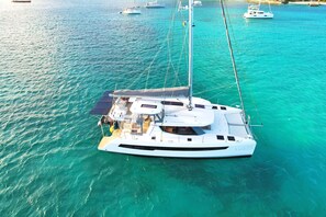 A white yacht with a covered deck and multiple masts, anchored in clear turquoise waters. - Apartment TalyJay - 2 bedrooms with swimming pools (Nettle Bay)