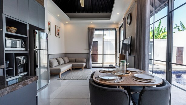 Una cocina moderna con zona de comedor, ventilador de techo y un amplio ventanal con vistas.