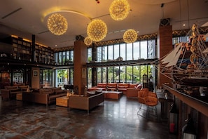 A spacious lobby with modern furniture, large windows, and decorative spherical chandeliers. - Modern 1-bedroom Suite With Pool Access in Kamala, Phuket (Kamala)